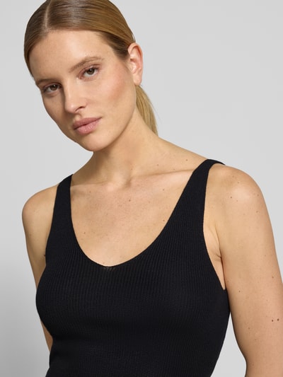 Frauenmodel trägt Regular Fit Strick-Top aus Viskose-Mix Modell 'NEWLEX' von Vero Moda, unifarben schwarz, Nahaufnahme Oberkörper.