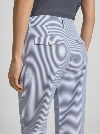 Vrouwenmodel draagt Hose aus Seersucker in verkürzter Passform van Christian Berg Woman met blauw-wit streep patroon, steekzakken en achterzakken, context: dames broek, seersucker, verkorte pasvorm, steekzakken, achterzakken, bandwijdte maat 36: 40 cm, binnenbeenlengte maat 36: 65 cm. Detailopname achterkant.