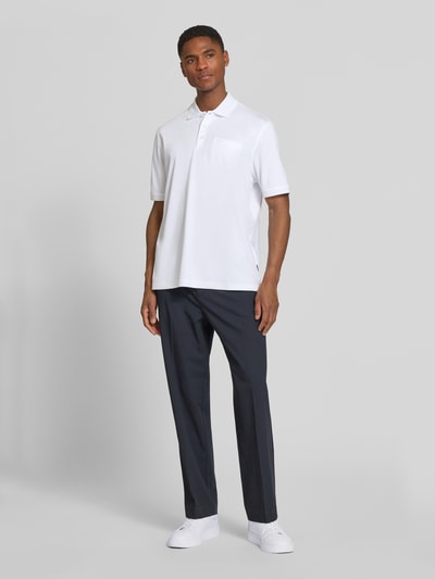 Männermodel trägt Regular Fit Poloshirt mit Brusttasche und Label-Stitching von bugatti, weiß, Polokragen, Knopfleiste, Ganzkörperansicht von vorne. Herren Poloshirt, Rückenlänge bei Größe M 70 cm.