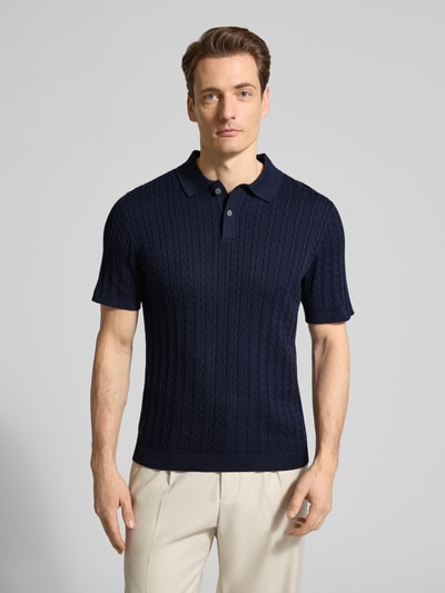 Männermodel trägt Slim Fit Poloshirt in Strick-Optik von Christian Berg Men, dunkelblau, reine katoen, polokraag, korte mouw, ganzkörperansicht von vorne.