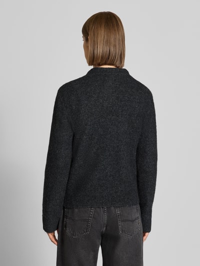 Vrouwenmodel draagt zwarte gebreide pullover met labeldetail Model 'Curtis' van Carhartt Work In Progress, materiaalmix met wol, getailleerd, ribboorden, ruglengte maat S 55 cm, mouwlengte maat S 60 cm, volledig van achteren
