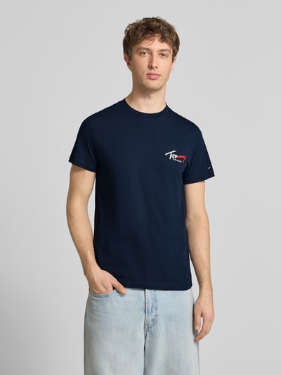 Männermodel trägt Slim Fit T-Shirt aus reiner Baumwolle von Tommy Jeans in Optik: Unifarben, Label-Print, Logo-Stitching, Kurzarm, Rundhals, Ganzkörperansicht von vorne.