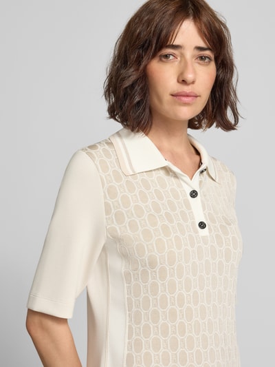 Frauenmodel trägt Polokleid im Allover-Look mit Knopfleiste von Marc Cain aus Viskose-Mix, cremige Farben, Strukturmuster, Nahaufnahme Oberkörper.