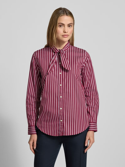 Vrouwenmodel draagt Overhemdblouse met knoopsluiting model 'NUSILA' van Lauren Ralph Lauren, puur katoen, los model, strikdetail, frontaal geheelaanzicht.