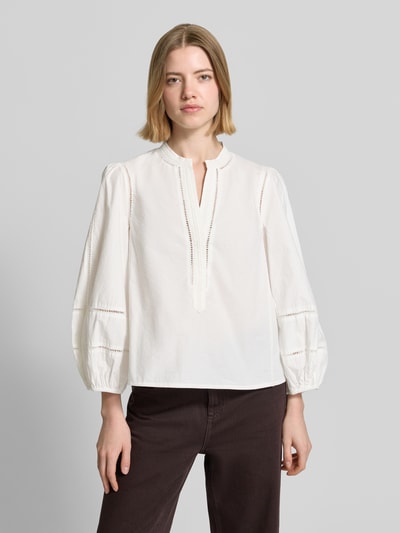 Frauenmodel trägt Relaxed Fit Bluse mit Loch-Stickerei Modell 'Ajour' von Stefanel aus reiner Baumwolle, Weiß, langärmelig, Ganzkörperansicht von vorne.