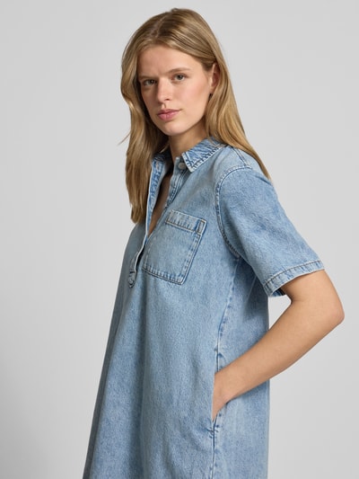 Frauenmodel trägt Relaxed Fit Minikleid in Denim-Optik Modell 'Amara' von JJXX aus Reine Baumwolle, hellblaue Farbe, Nahaufnahme Oberkörper.