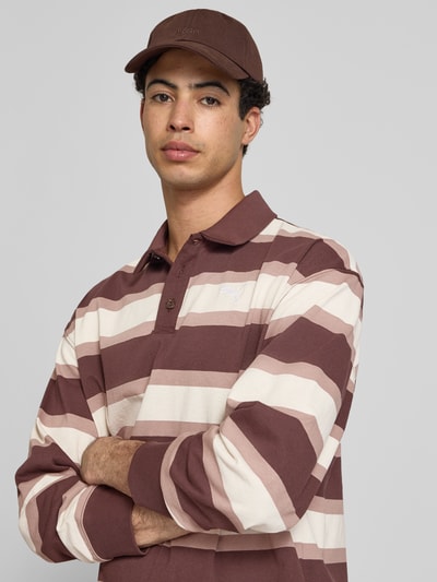 Männermodel trägt Regular Fit Poloshirt mit elastischen Ärmelabschlüssen von PUMA PERFORMANCE, gestreift, Reine Baumwolle, Nahaufnahme Oberkörper.
