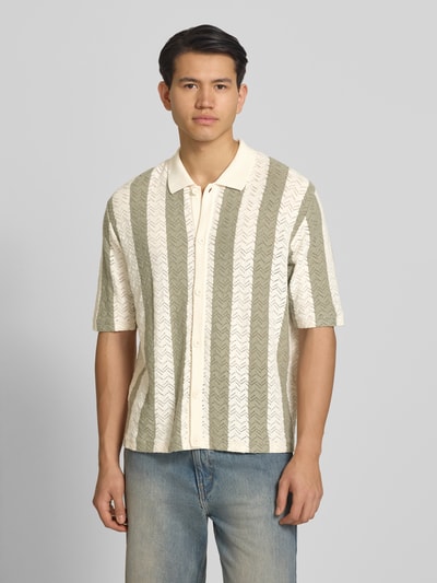 Männermodel trägt Regular Fit Poloshirt mit Knopfleiste Modell 'TYLER' von Jack & Jones, beige-grün gestreift, Baumwoll-Mix, Halbarm, Ganzkörperansicht von vorne.