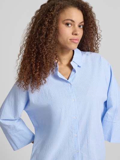 Frauenmodel trägt Boxy Fit Bluse aus reiner Baumwolle Modell 'AUGUSTA' von Only, Optik: Allover-Muster, gestreift, Hemdkragen, einreihige Knopfleiste, Kimonoärmel, Twillgewebe, Nahaufnahme Oberkörper.
