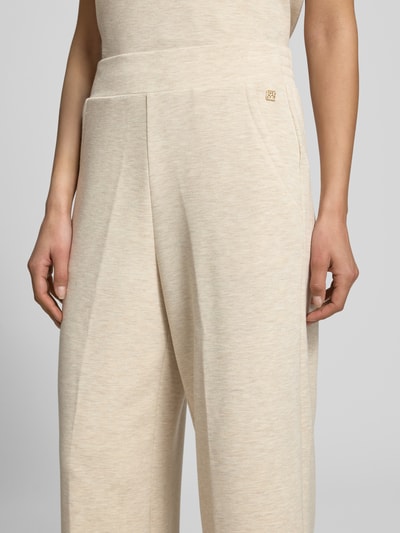 Frauenmodel trägt Sweatpants aus Viskose-Mix mit Label-Detail Modell 'Namara' von MOS MOSH, Wide-Leg-Fit, seitliche Eingrifftaschen, elastischer Bund, beige melierte Textur, Damen, Nahaufnahme Oberkörper. Kontext: Innenbeinlänge bei Größe S 69 cm, Stretch-Anteil.