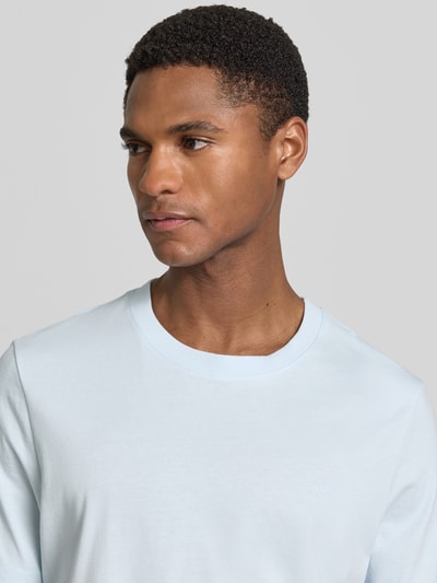 Männermodel trägt Regular Fit T-Shirt aus reiner Baumwolle von s.Oliver RED LABEL, Optik: Unifarben, Label-Schriftzug, Nahaufnahme Oberkörper