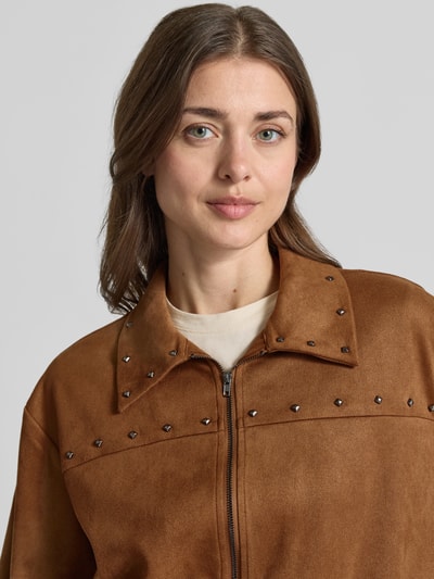 Kobiece modelka nosi Regular Fit Bomberjacke mit Nieten Modell 'ANDREA' von Vero Moda, efekt: jednolity kolor, zamek błyskawiczny, nity, długi rękaw, elastyczne zakończenie rękawów i dołu, wpuszczane kieszenie, ujęcie: zbliżenie na górną część ciała.