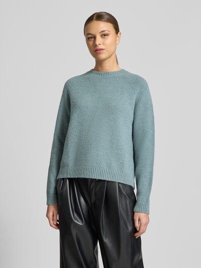 Frauenmodel trägt Regular Fit Strickpullover aus Alpaka-Mix mit Baumwoll-Anteil Modell 'FEBISAN' von BOSS in Hellblau, unifarben, Rundhals, langarm, gerippte Abschlüsse, Strickstruktur, Ganzkörperansicht von vorne.
