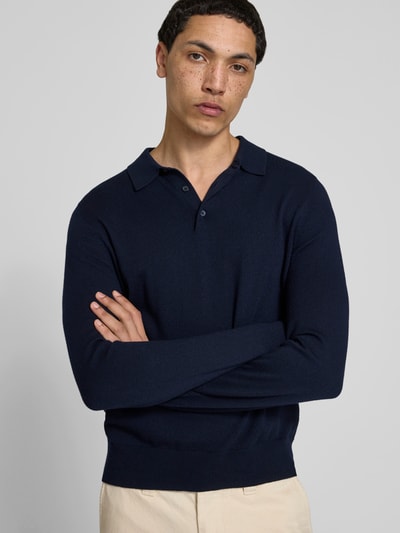 Männermodel trägt Slim Fit Poloshirt aus Woll-Mix von Filippa K in Dunkelblau mit Strick-Optik, elastischen Abschlüssen, langärmelig, Rückenlänge bei Größe M 67 cm, Nahaufnahme Oberkörper.