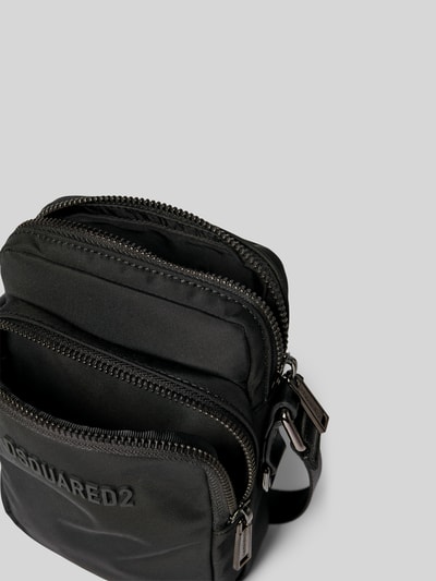 Produktfoto, Crossbody Bag mit Label-Detail von Dsquared2 aus schwarzem Material-Mix mit Hauptfach und Nebenfach, silberne Reißverschlüsse, verstellbarer Schulterriemen, kompakte Größe 15 cm Breite, 19 cm Länge, 7 cm Tiefe