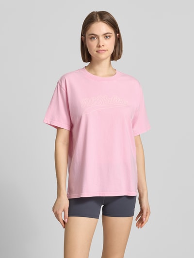Frauenmodel trägt Relaxed Fit T-Shirt mit Logo-Print Modell 'Formation' von P.E Nation in Rosa aus Reine Baumwolle, Rundhalsausschnitt, Ganzkörperansicht von vorne.