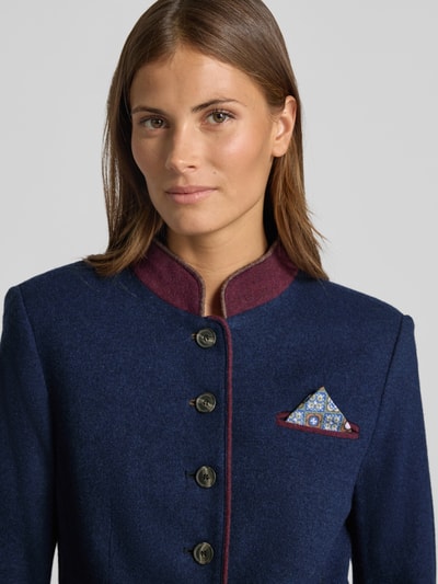Vrouwenmodel draagt blazer uit wolmix met pochet, getailleerd model van White Label, blauw met bordeaux detail, Nahaufnahme Oberkörper. Context: dames blazer van White Label, wolmix, getailleerd model, korte opstaande kraag, knoopsluiting, borstzak met pochet, opgestikte steekzakken, ruglengte bij maat 36: 52 cm, borstwijdte bij maat 36: 46 cm, mouwlengte bij maat 36: 64 cm.