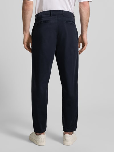 Männermodel trägt dunkelblaue Chino mit Eingrifftaschen Modell 'PEPE' von Casual Friday, Regular Fit, Ganzkörperansicht Rückansicht.