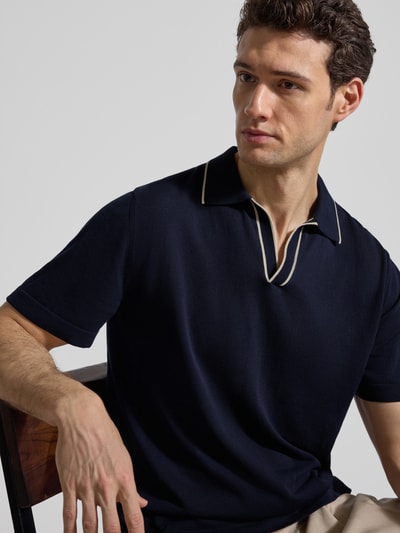 Męski model nosi Regular Fit Poloshirt aus Baumwolle von CRUNA, imitacja dzianiny, kołnierzyk polo, krój regular fit, bawełna, długość tyłu w rozmiarze 50: 67 cm, ciemnogranatowy, gładka tekstura, zbliżenie na górną część ciała z przodu