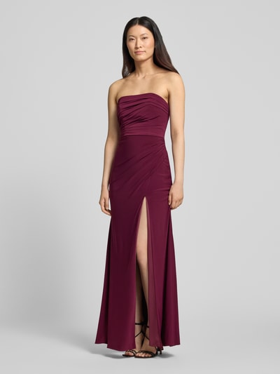 Frauenmodel trägt Slim Fit Abendkleid in Maxilänge mit Gehschlitz von Hey Kyla, Elastischer-Material-Mix, Raffungen, schulterfrei, weinrote Farbe, glatte Textur, Ganzkörperansicht von vorne. Rückenlänge bei Größe 36: 132 cm, Brustweite bei Größe 36: 28 cm.