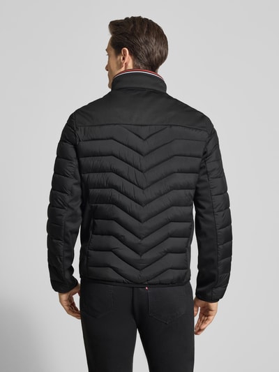 Männermodel trägt Regular Fit Steppjacke mit Stehkragen von Tom Tailor, Optik: Unifarben, Kontrastdetails, Ganzkörperansicht Rückansicht.