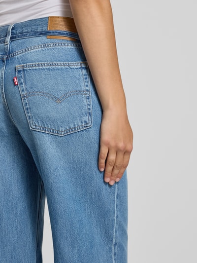 Frauenmodel trägt Oversized Weite Hose aus Baumwoll-Lyocell-Mix Modell '300®' von Levi's® 300, hellblaue Denim-Textur, Nahaufnahme Rückansicht.