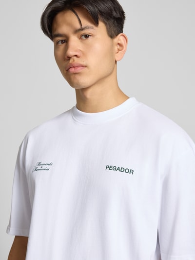 Männermodel trägt Oversized Herren T-Shirt mit Label-Detail Modell 'Rochefort' von Pegador aus Reine Baumwolle, Nahaufnahme Oberkörper.