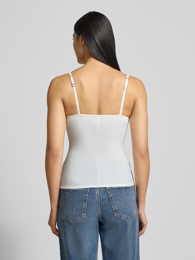 Frauenmodel trägt körpernahes, weißes BH-Top mit gepolsterten, gemoldeten Cups Modell 'ALLURE' von Hanro im Material-Mix mit Stretch-Anteil, verstellbare Träger, Ganzkörperansicht Rückansicht.
