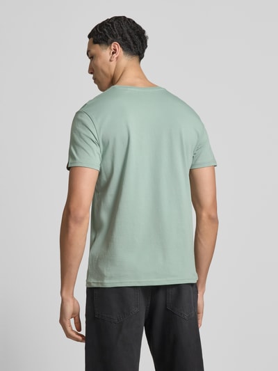 Männermodel trägt T-Shirt mit Label-Details Modell 'BASIC' von Alpha Industries aus Reine Baumwolle in Mint, Gerader-Schnitt, Rückenlänge 67 cm, Ganzkörperansicht Rückansicht
