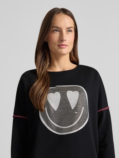 Modelka kobieca nosi czarne Sweatshirt mit Label-Detail von miss goodlife z bawełny, luźny krój, żebrowane wykończenia, ujęcie górnej części ciała z przodu.