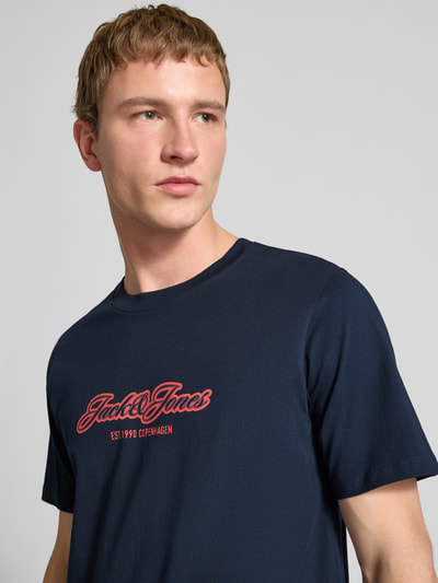 Männermodel trägt Regular Fit T-Shirt mit Logo-Print von JACK & JONES aus reiner Baumwolle, navy, Nahaufnahme Oberkörper.