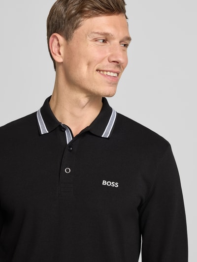 Mężczyznamodel nosi Koszulkę polo Regular Fit z czystej bawełny Model 'PLISY' od BOSS Green, efekt: jednolity kolor, pika, wyhaftowane logo, kołnierzyk polo, dekolt henley, długi rękaw, listwa guzikowa, ujęcie: zbliżenie na górną część ciała.