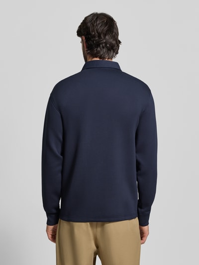 Männermodel trägt Regular Fit Poloshirt aus Viskose-Mix Modell 'EMANUEL' von SELECTED HOMME in Dunkelblau, Ganzkörperansicht Rückansicht. Kontext: Unifarbenes Herren Poloshirt mit Polokragen, kurzem Reißverschluss, langen Ärmeln mit elastischem Abschluss, Sweat-Optik.