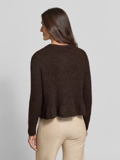 Frauenmodel trägt Regular Fit Strickjacke mit Woll-Anteil Modell 'Bows' von VILA in Dunkelbraun, beige Hose, gerippte Abschlüsse, Ganzkörperansicht Rückansicht.