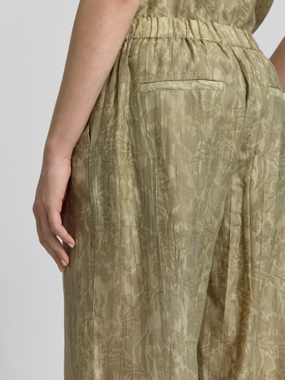 Frauenmodel trägt Wide Fit Stoffhose aus Lyocell-Mix von Jake*s Collection, floraler Allover-Print, elastischer Bund, Detailaufnahme seitlich