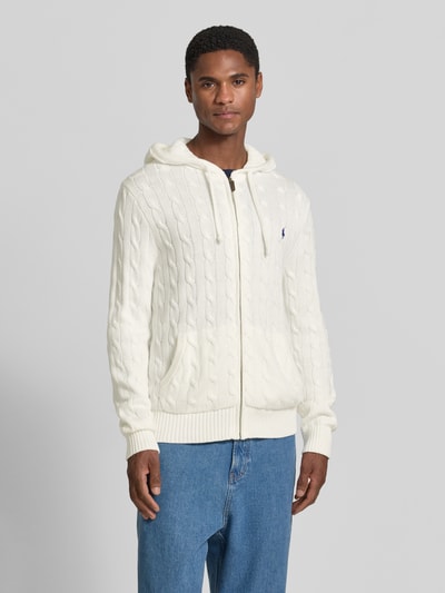 Męski model nosi Regular Fit Strickjacke aus reiner Baumwolle von Polo Ralph Lauren, kremowy kolor, dzianinowa faktura, Ganzkörperansicht z przodu.