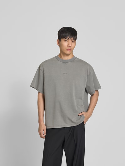 Männermodel trägt Relaxed Fit T-Shirt mit Logo-Stitching von WON HUNDRED in Grau, reine Baumwolle, Rundhalsausschnitt, Ganzkörperansicht von vorne.