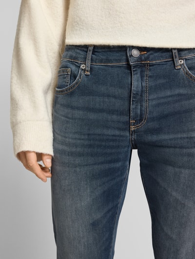 Männermodel trägt Slim Fit Jeans aus Baumwoll-Mix Modell 'LOOM' von Only & Sons in Dunkelblau, sichtbare Label-Stitchings, Nahaufnahme Oberkörper, Kontext: unifarbene Mid Waist Herrenjeans im 5-Pocket-Design aus Denim mit Gürtelschlaufen und verdecktem Reißverschluss.