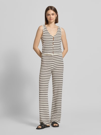 Frauenmodel trägt Strickhose in Streifen-Optik mit elastischem Bund von REVIEW, flared Cut, hell-dunkle Streifen, Ganzkörperansicht von vorne.