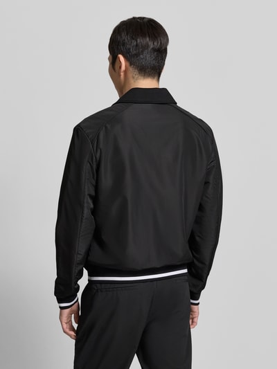 Männermodel trägt schwarze Jacke mit Label-Detail von Antony Morato, Struktur und Schnitt laut Kontext, Ganzkörperansicht Rückansicht.