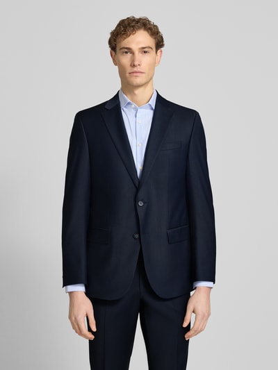 Męski model nosi Slim Fit Anzug mit 2-Knopf-Sakko Modell 'Grant' von Pierre Cardin, granatowy, gładka faktura, ganzkörperansicht von vorne. Krój slim fit, materiał z domieszką wełny, klapy z klapami, kieszenie z patkami, spodnie z zaprasowanym kantem, szerokość w rozmiarze 50: 43 cm, długość tyłu: 76 cm, szerokość ramion: 41 cm, długość rękawa: 65 cm, długość wewnętrzna nogawki: 83 cm.