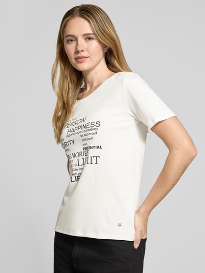 Frauenmodel trägt T-Shirt mit Statement-Print und Ziersteinbesatz von monari aus reiner Baumwolle, Regular-Fit, Rundhalsausschnitt, Vorderansicht, Nahaufnahme Oberkörper.