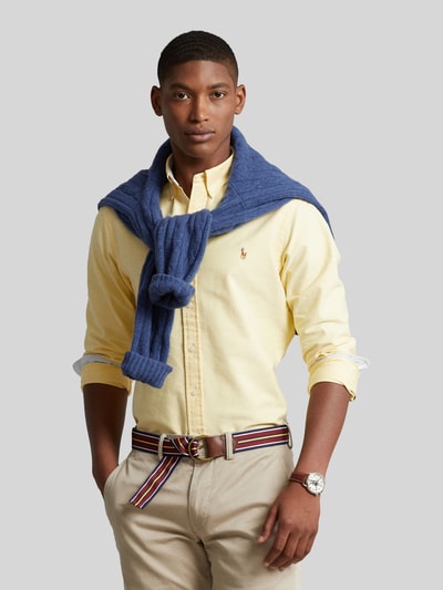 Männermodel trägt Slim Fit Freizeithemd aus reiner Baumwolle von Polo Ralph Lauren in hellgelb, glatte Struktur, Ganzkörperansicht von vorne.