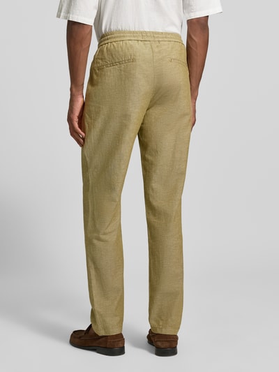 Männermodel trägt Hose mit Leinen-Anteil und französischen Eingrifftaschen von Scotch & Soda in Beige, Baumwoll-Mix, Gerade, Ganzkörperansicht Rückansicht.