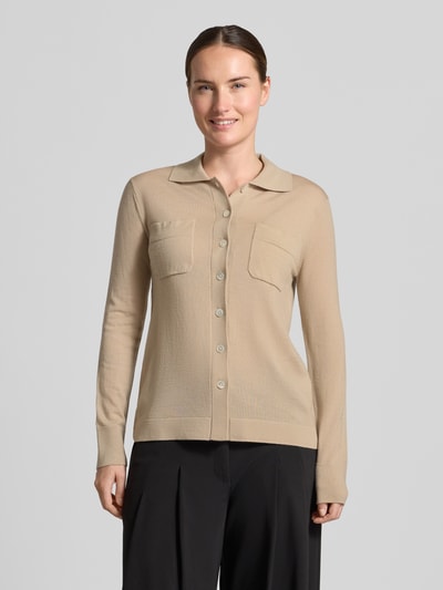 Frauenmodel trägt Strickjacke aus reiner Schurwolle Modell 'DETTO' von MM by Max Mara in Beige, strukturierte Oberfläche, Ganzkörperansicht von vorne.