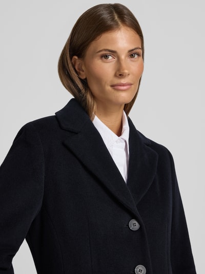 Vrouwenmodel draagt Mantel aus Woll-Mix mit Reverskragen und Pattentaschen van FUCHS SCHMITT in zwart, mix van wol en kasjmier, straight fit, knoopsluiting, klepzakken, ruglengte maat 36: 95 cm, schouderbreedte: 42 cm, borstwijdte: 48 cm, mouwlengte: 66 cm, close-up bovenlichaam.