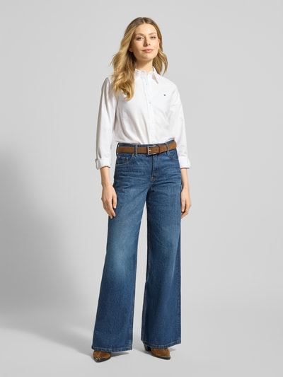 Vrouwenmodel draagt Relaxed Fit Hemdbluse aus reiner Baumwolle van Tommy Hilfiger, look: effen, pasvorm: relaxed fit, overhemddkraag, logodetail, achterpas, knoopsluiting, lange mouw met manchet, afgeronde rompzoom, Oxford, puur katoen. Volledige lichaamsaanzicht van voren.