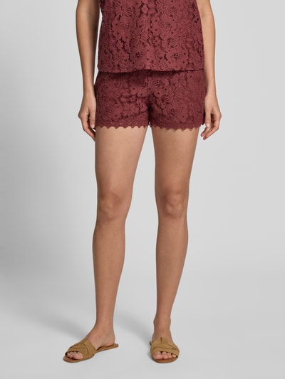 Frauenmodel trägt Regular Fit Sweatshorts mit Spitze Modell 'HONEY' von Vero Moda, einfarbig in Bordeaux, Baumwoll-Mix mit Spitzenmuster, Nahaufnahme Oberschenkel.
