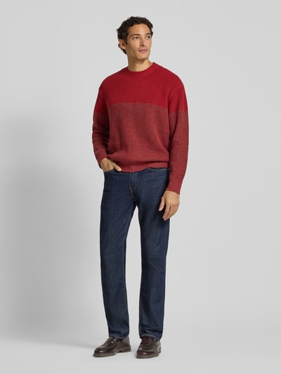 Männermodel trägt Strickpullover mit Rundhalsausschnitt von Armani Exchange, rot, Grobstrick, Baumwoll-Mix, Regular Fit, Ganzkörperansicht von vorne.