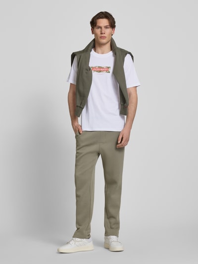 Männermodel trägt T-Shirt mit Logo und Rundhalsausschnitt von Jack & Jones aus weißer Baumwolle, Regular Fit, Ganzkörperansicht von vorne.